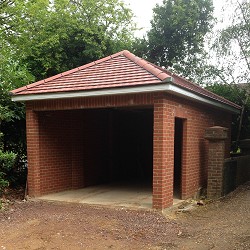 A new brick garage with a tiled hipped roof